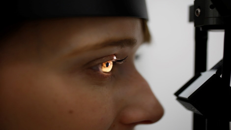 a close up of a student's eye. a light is shining into it for the eye exam