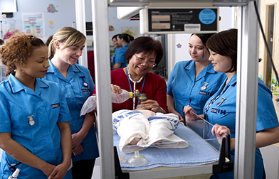Group of students being taught using training mannequin