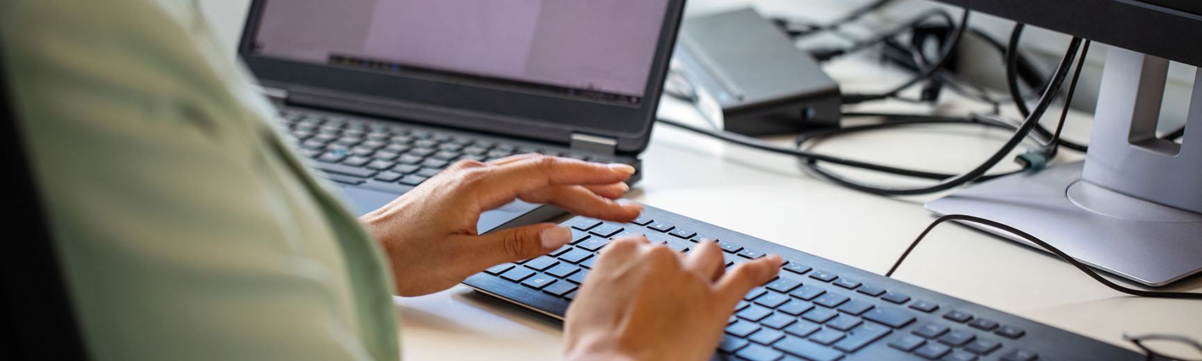 Picture of someone at a computer typing on a keyboard