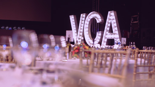 Light up letter standing on a stage spell out 'VCA'