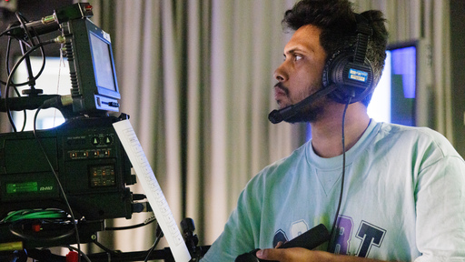 Student looking through camera in film and TV Studio 