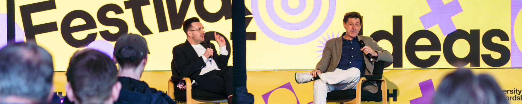 Two people speaking on stage